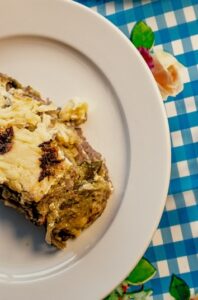 Freshly baked slice of classic beef lasagna with melted cheese on a plate