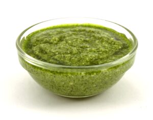 A bowl of fresh green basil pesto for traditional Pesto Genovese with Trofie.