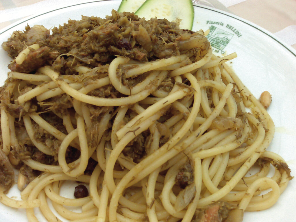 Pasta con le sarde served in a dish with toasted breadcrumbs, wild fennel, and pine nuts