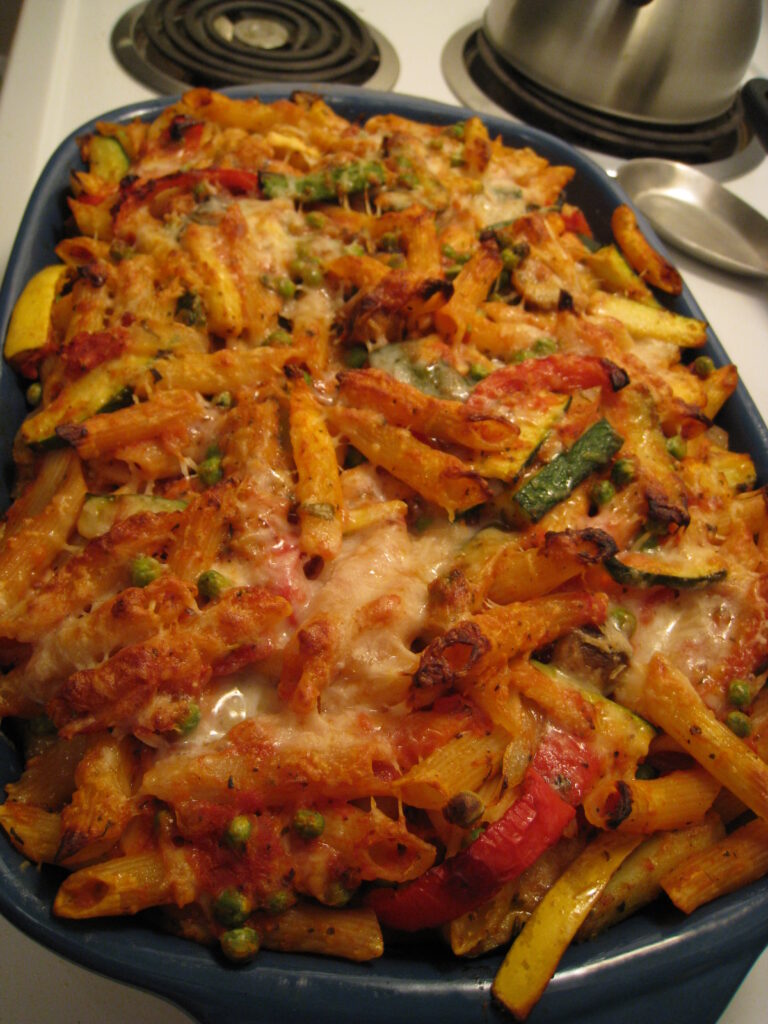 A plate of fresh Mediterranean Vegetable Pasta topped with roasted vegetables, cherry tomatoes, and herbs